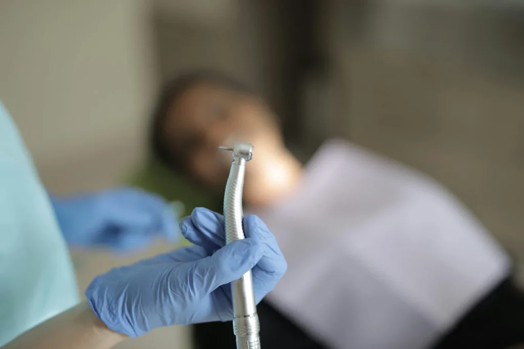 Dental professional using precision tools in clinic environment for handpiece repair and servicing illustration